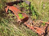 a rusted out machine sitting in the middle of a field