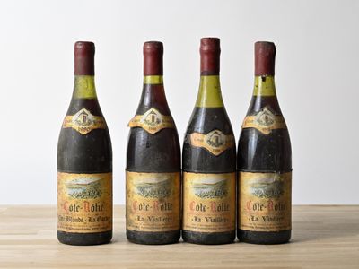 four bottles of wine are lined up on a wooden table