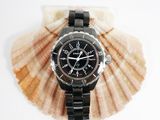 a watch sitting on top of a shell on a white surface