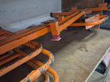 une étagère sur laquelle sont disposées plusieurs barres métalliques orange