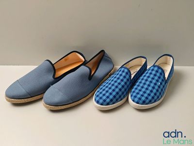 three pairs of blue and white slippers sitting on top of a table