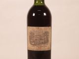 une vieille bouteille de vin posée sur une table blanche