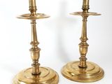 pair of antique brass candlesticks on stands on a white background