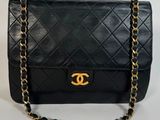 un sac Chanel noir avec des finitions dorées et une chaîne