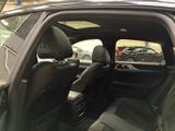 a black car with the door open in a parking lot
