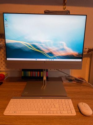 a computer monitor sitting on a desk with a keyboard and mouse