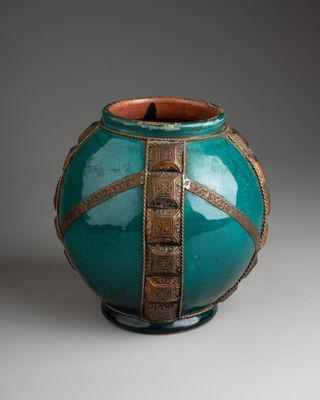 a green vase with a gold stripe around it