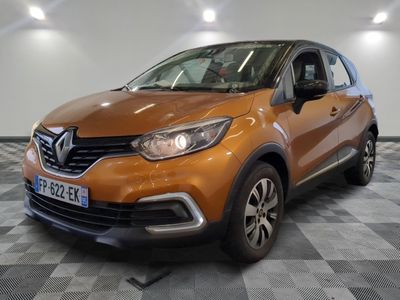 La voiture orange est garée sur un sol à damier dans le garage.