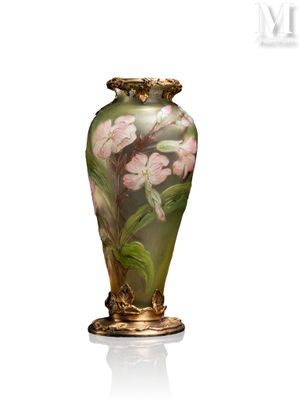 un vase avec des fleurs peintes dessus, posé sur une table