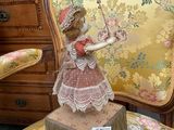 a small statue of a girl on a chair