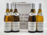 three bottles of white wine sitting next to each other in front of a box