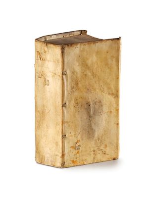 un vieux livre posé sur une table à côté d'un fond blanc