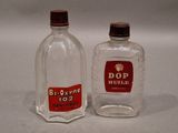 two empty bottles of liquor sitting on a table next to each other
