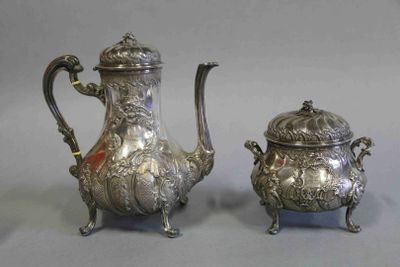 paire de théières anciennes en argent sur un socle, sur fond gris