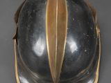 an old helmet with a gold rim sits on a gray surface