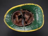 an old green and yellow helmet with a hole in the middle