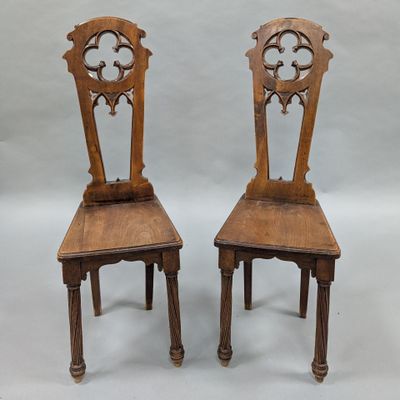 two wooden chairs with a carved back and a wooden seat
