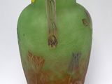 a green vase with a flower design on it