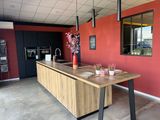 une cuisine avec un plan de travail en bois et un mur rouge