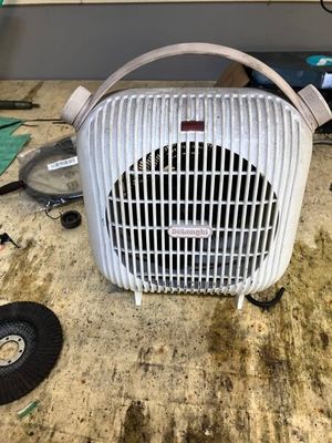 un ventilateur posé par terre à côté d'une table