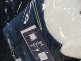 a white teddy bear sitting inside of a plastic bag