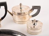 a silver plate with a silver tea pot and a silver plate with a silver tea pot and a silver plate with a silver tea pot on it