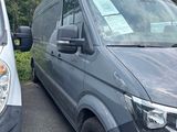 the grey van is parked next to the white van in the parking lot
