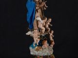 a statue of the virgin with angels and chers on a black background