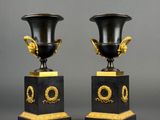 pair of black and gold vases on pedestals with gold decoration