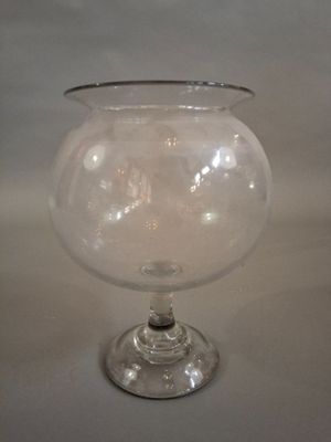 un vase en verre transparent bordé d'argent, posé sur une table