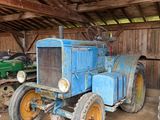 deux vieux tracteurs dans une grange au toit en bois