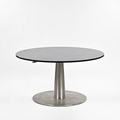 un gros plan d'une table avec un piètement en métal et un plateau en verre