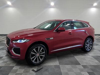 a red 2019 jaguar pace is parked in a showroom