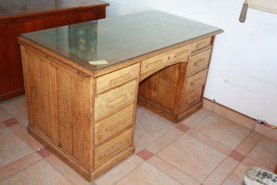 a wooden desk with a glass top in a room