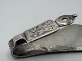 a silver spoon with a metal handle on a white surface