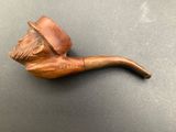 an old pipe with a man ' s face on it sitting on a table