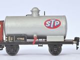 trois wagons de train miniature alignés sur une surface blanche