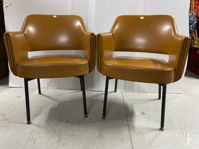 deux fauteuils en cuir marron aux pieds noirs dans une pièce