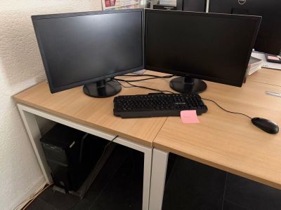 un bureau sur lequel sont posés deux écrans d'ordinateur et un clavier