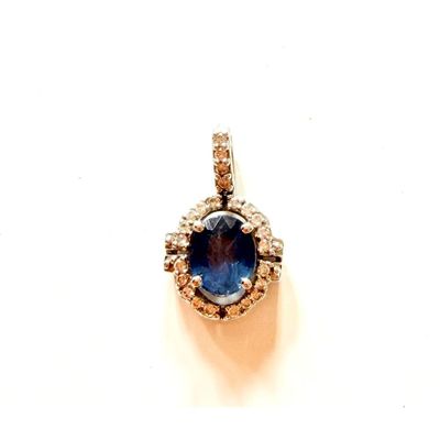 une image représentant un pendentif composé d'un saphir bleu et de diamants, sur fond blanc