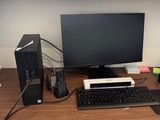 a computer desk with a monitor, keyboard, mouse and other office supplies