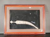 a picture of a picture of a knife in a shadow box