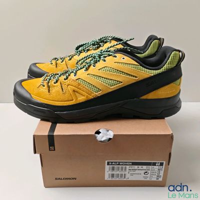un gros plan sur une paire de chaussures jaunes et noires posées sur une boîte