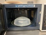 a microwave with a plastic dome inside of it