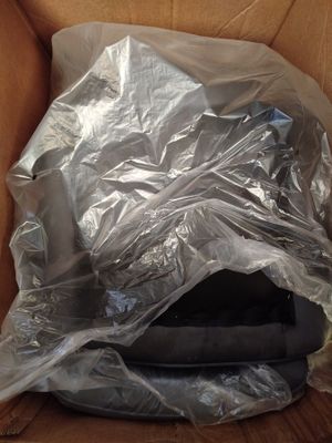 une boîte en carton contenant un ordinateur portable emballé dans du plastique