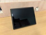 une tablette posée sur une table devant un mur