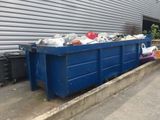 une benne bleue garée devant un immeuble