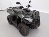 une photo d'un quad vert garé dans un garage