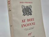 un vieux livre posé sur une table à côté d'une table blanche