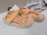 two pairs of children ' s sandals on a table